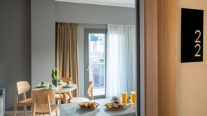 A dining area with a table set for breakfast, including plates of food and drinks, and a number sign indicating room 22. - Chroma Fashion Rooms & Apartments (Chalandri)