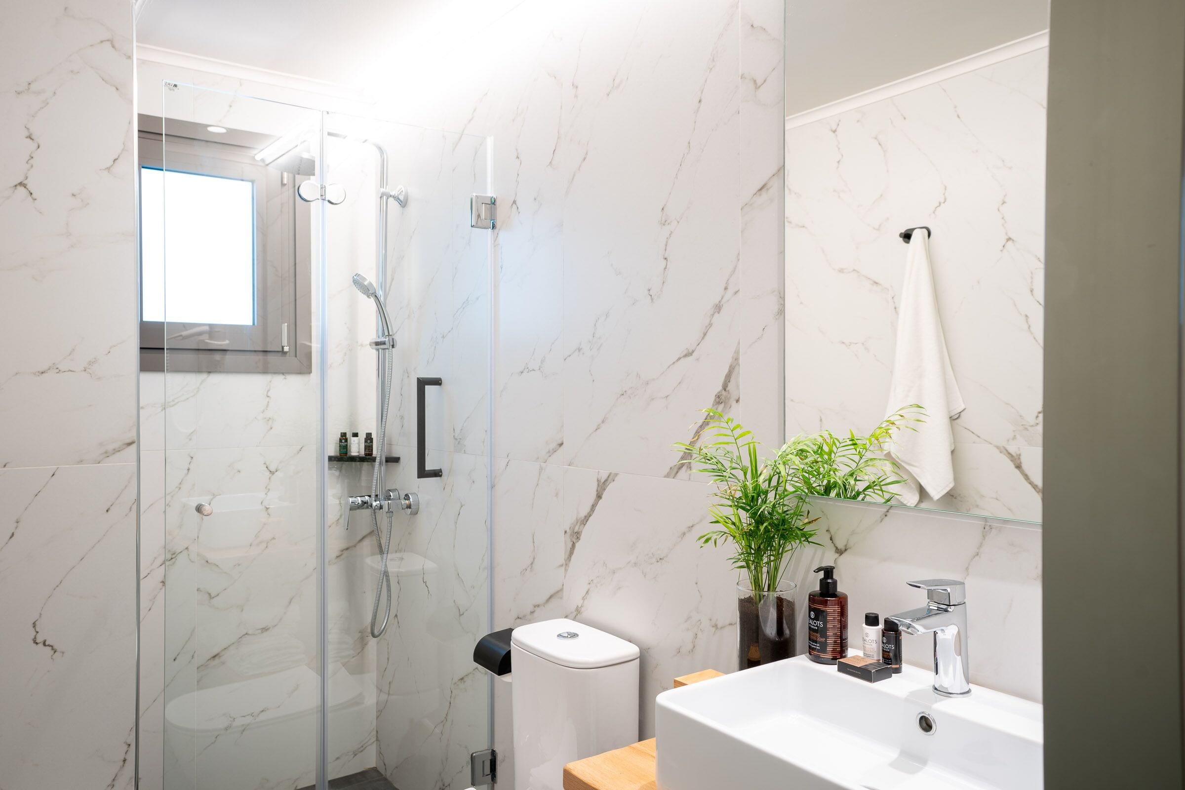 designer toiletries, hair dryer, slippers, towels