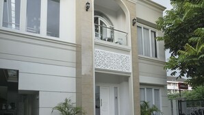 A two-story building with a balcony, a decorative entrance, and potted plants. - Royal Homy Syariah (Depok)