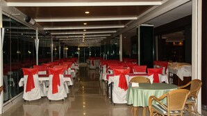 A spacious indoor dining area with rows of tables and chairs, large windows, and a polished floor. - Ata Hotel Kumburgaz (Istanbul)