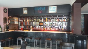 A bar with a black counter, multiple stools, and a variety of liquor bottles. - Ata Hotel Kumburgaz (Istanbul)