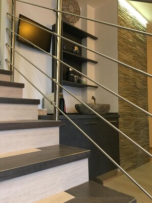 A modern staircase with metal railings, built-in shelves, and a decorative wall panel. - B&B Terra Mare (Trecchina)