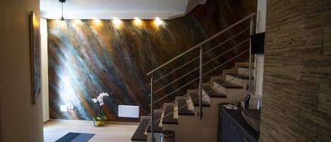 Un interior moderno con una escalera, un panel de madera decorativo y un diseño minimalista.