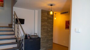 Una escalera de diseño moderno, un lavabo de piedra sobre un mueble oscuro y una pared con textura.