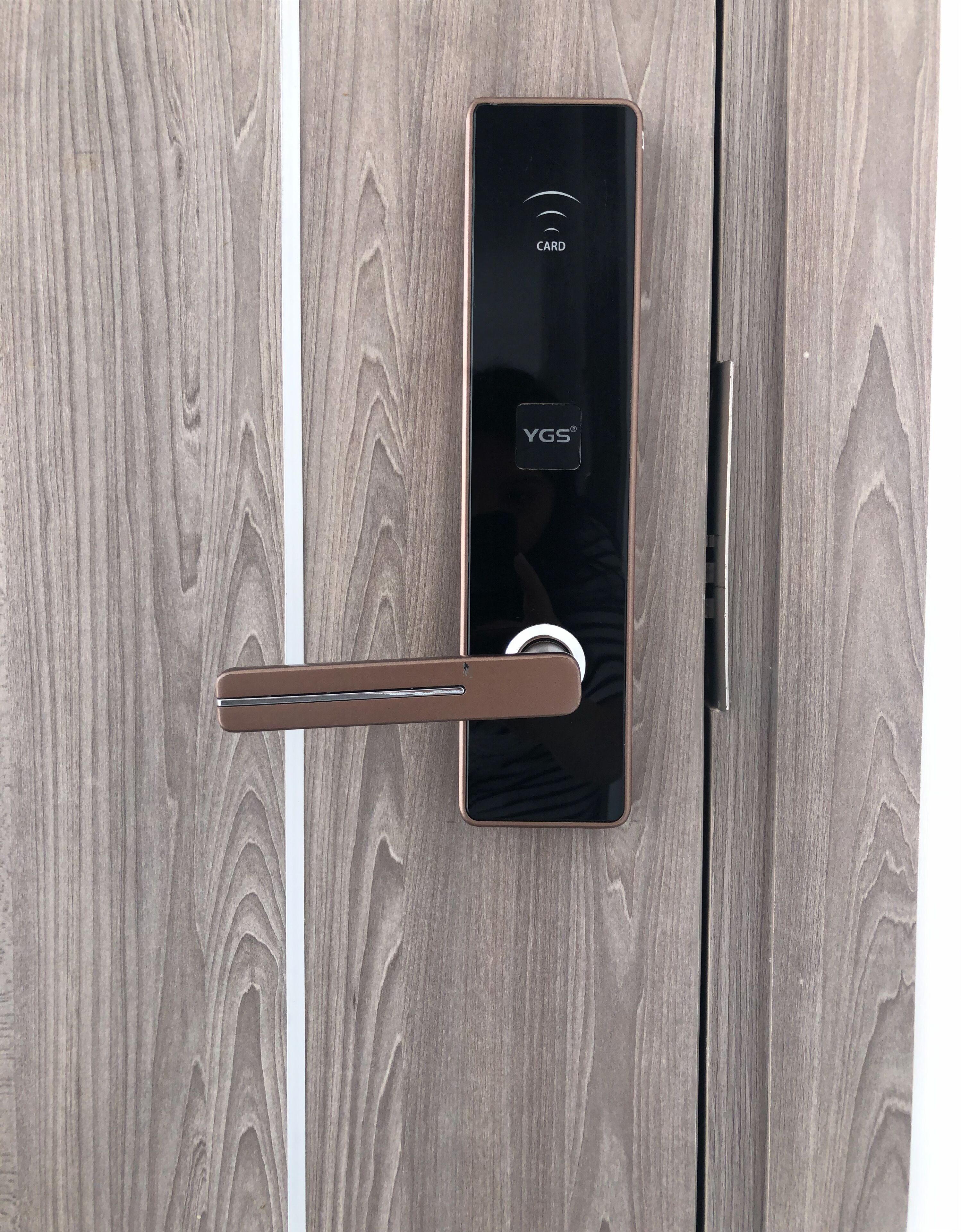 A modern door with a card reader and a sleek handle.