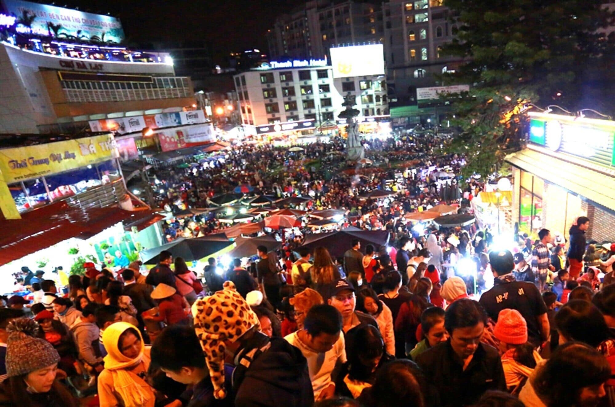 A crowded outdoor market with various stalls and people.