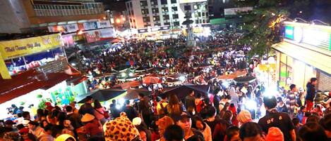 A crowded outdoor market with various stalls and people.