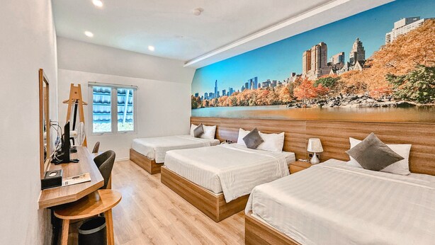 A hotel room with two beds, a desk with a computer, a chair, and a large cityscape mural on the wall. -  NATURE LAND 2 - Song Anh Hotel Dalat (Xuan Huong - Da Lat)