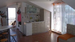 A spacious living area with a kitchen, a dining table with chairs, and a sofa. - Studio with sea view and air conditioning. (Rovinj)