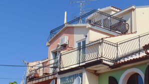 A multi-story building with balconies, a satellite dish, and a visible antenna. - Studio with sea view and air conditioning. (Rovinj)