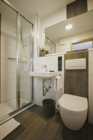 Comfort tweepersoonskamer | Badkamer | Een douche, gratis toiletartikelen, een haardroger, handdoeken