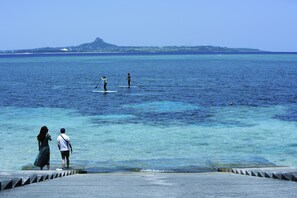 A pier with clear blue water and a distant island. - Ocean view terrace BISE (Motobu)