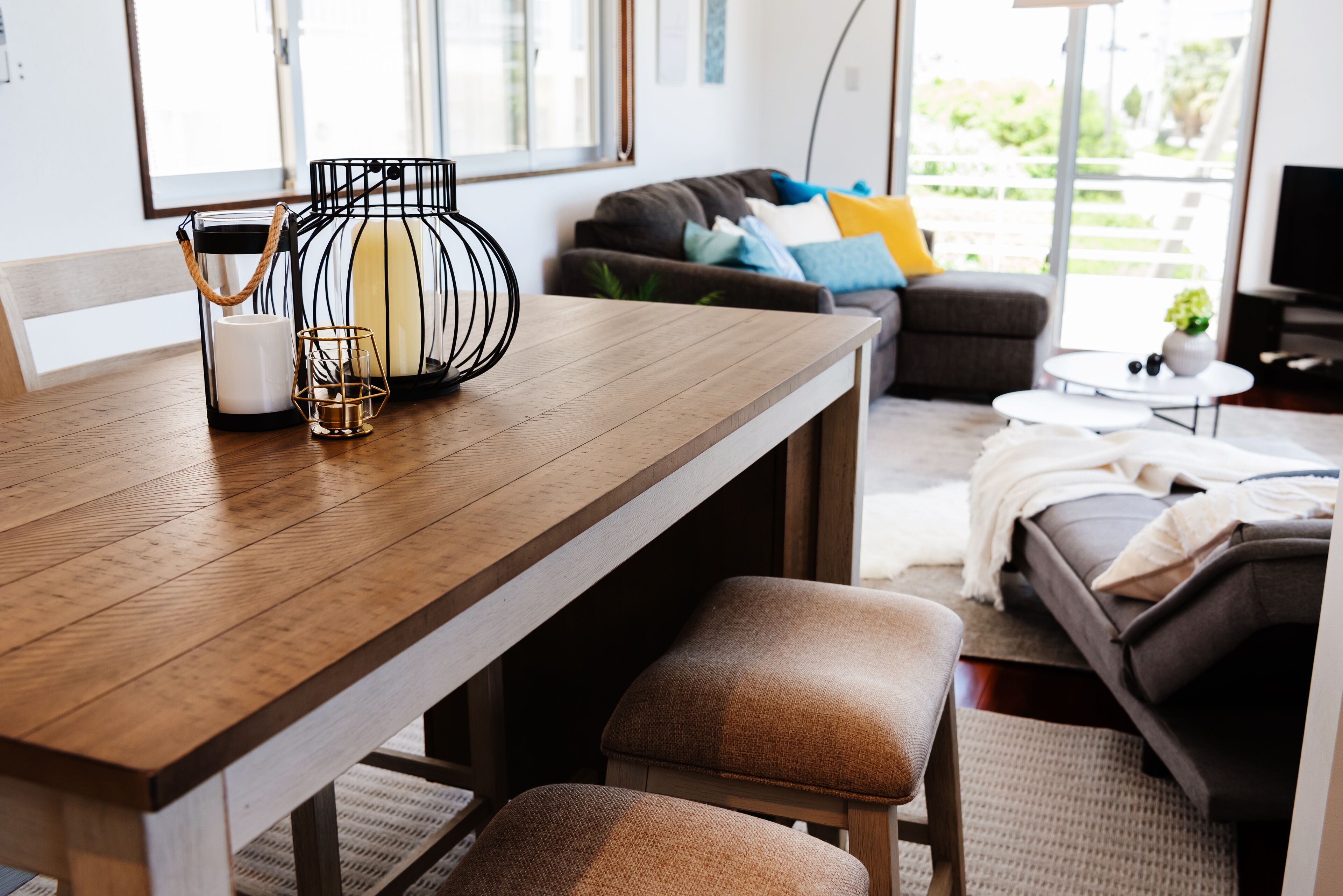Un salon moderne avec une table à manger en bois, des sièges confortables et un canapé agrémenté de coussins colorés.