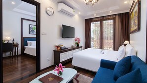 A hotel room with a bed, a sofa, a TV, a desk, and a window with curtains. - Hanoi Central Hotel & Residences (Hanoi)