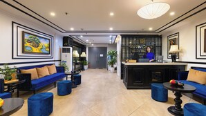 A modern hotel lobby with a reception desk, sofas, and a large painting on the wall. - Hanoi Central Hotel & Residences (Hanoi)