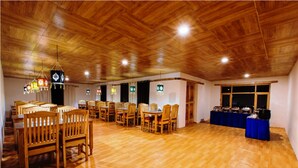 A spacious room with wooden flooring and ceiling, featuring multiple wooden tables and chairs arranged for dining. - TIH Magpie Camp (Leh)