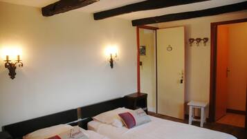 Een hotelkamer met twee bedden, een houten plafond en wandlampen.