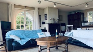 Una sala de estar con un sofá azul, una mesa de centro de madera y una chimenea.