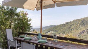 Mesa de madera al aire libre con vista a un paisaje montañoso.