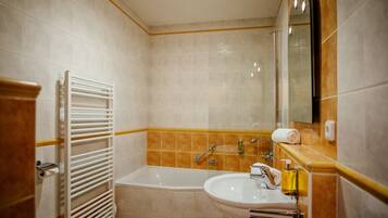 A bathroom with a bathtub, a sink, a mirror, and a towel rack.