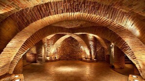 An arched brick interior with a central stone wall and a tiled floor.