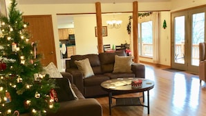 A cozy living room with a dark brown sofa, a coffee table, and a Christmas tree. - LOWEST FALL RATES ON WHITE RIVER W/ 2 SLIP COVERED BOAT DOCK! GREAT FISHING!! (Flippin)