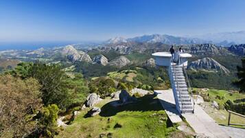 Escadaria que leva a uma plataforma de observação com vista panorâmica de uma paisagem montanhosa.