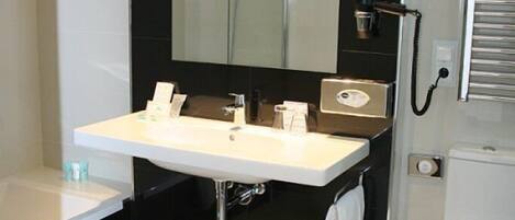 A modern bathroom with a white sink, black vanity, and a glass-enclosed shower.
