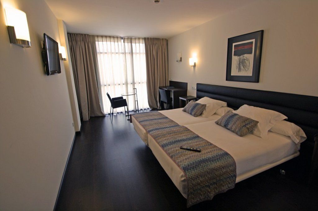 Una habitación de hotel con una cama grande, un escritorio y una silla.