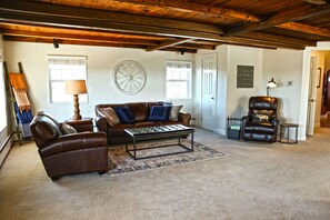 Relax in this inviting living room with a leather sofa, armchair, and wooden coffee table.