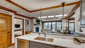 A modern kitchen with a large island, built-in appliances, and a view of the outdoors.