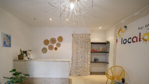 Een moderne keuken met witte kasten, een centraal eiland en een decoratieve plafondlamp.