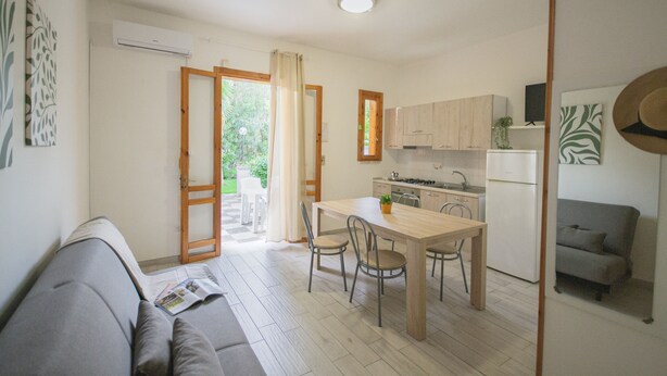Een compacte wooneenheid met een kitchenette, een eethoek en een slaapbank.