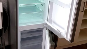An open refrigerator with multiple shelves and a freezer compartment. - Neckarzeit (Neckarwestheim)