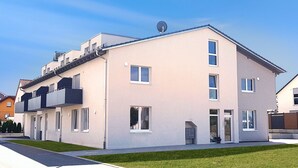 A modern two-story apartment building with a flat roof, large windows, and a satellite dish. - Neckarzeit (Neckarwestheim)
