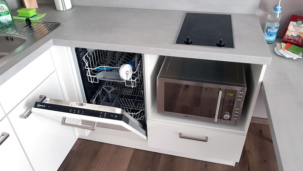 A compact kitchen with a dishwasher, microwave, and a small countertop. - Neckarzeit (Neckarwestheim)
