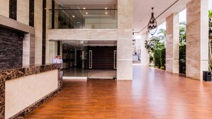 A spacious lobby with a marble reception desk, a glass entrance, and a view of the outdoors. - Maldives Resort by PSR ASIA (Pattaya)