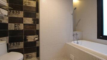 Une salle de bain avec un carrelage à motifs géométriques, des toilettes, une baignoire et des murs recouverts de carreaux ornés de chiffres.