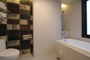 A bathroom with a checkered floor, a toilet, a bathtub, and tiled walls with numbers. - Mz1090 B&B (Hengchun)