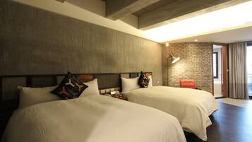 Habitación de hotel con dos camas, una pared de piedra, una lámpara moderna y vistas al exterior.