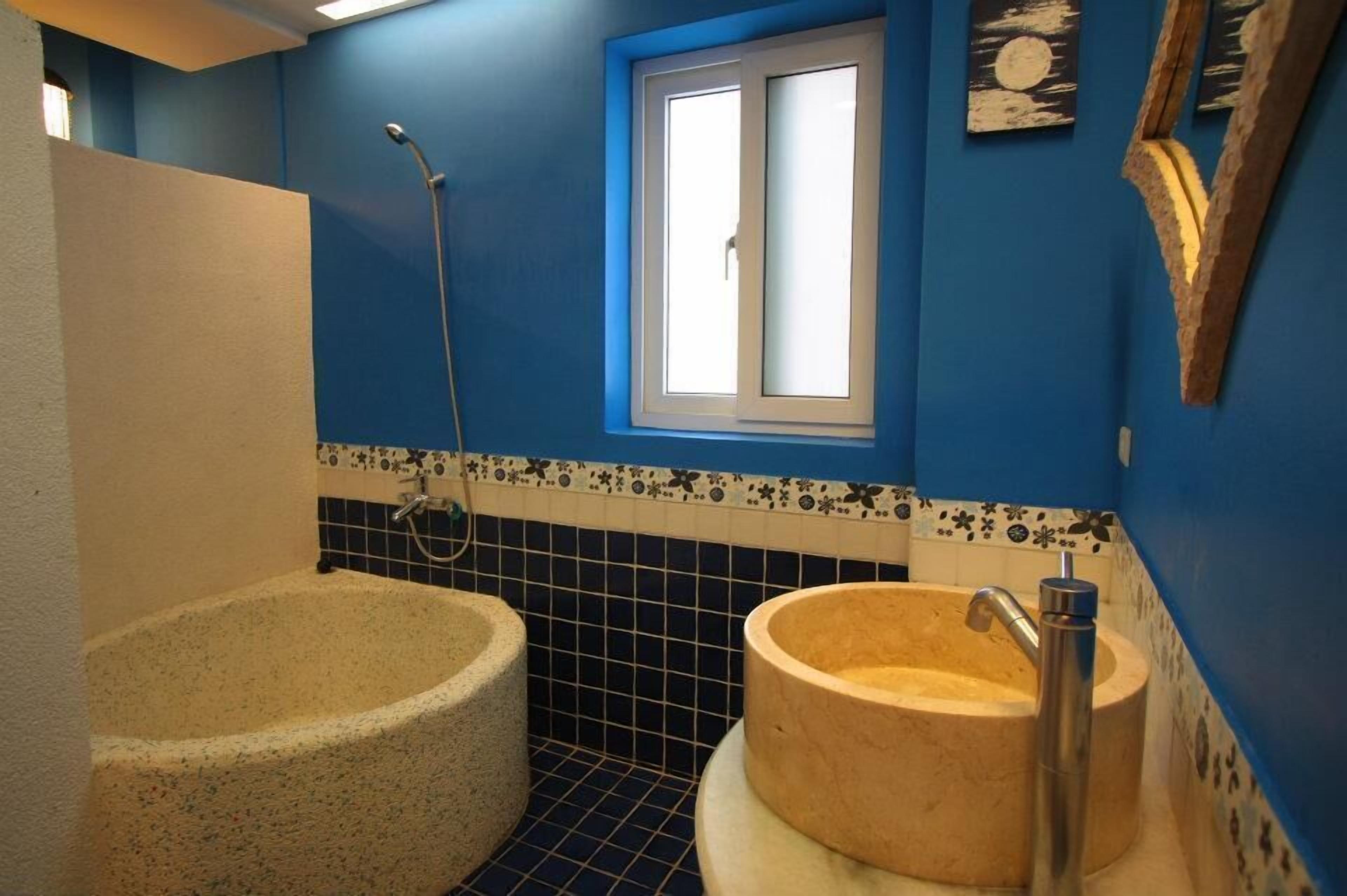 Un baño con bañera, lavabo y ducha.