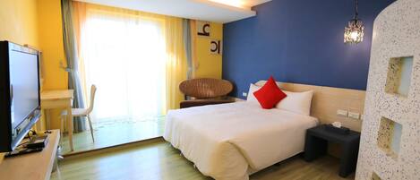Una habitación de hotel con cama, mesita de noche, televisor y una silla.