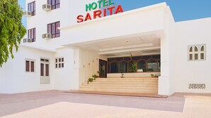 En modern hotellentréd med en skylt som visar texten ”HOTEL SARITA”.