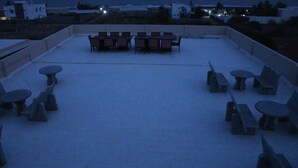 Terraza en la azotea con mesas y sillas dispuestas para comer.