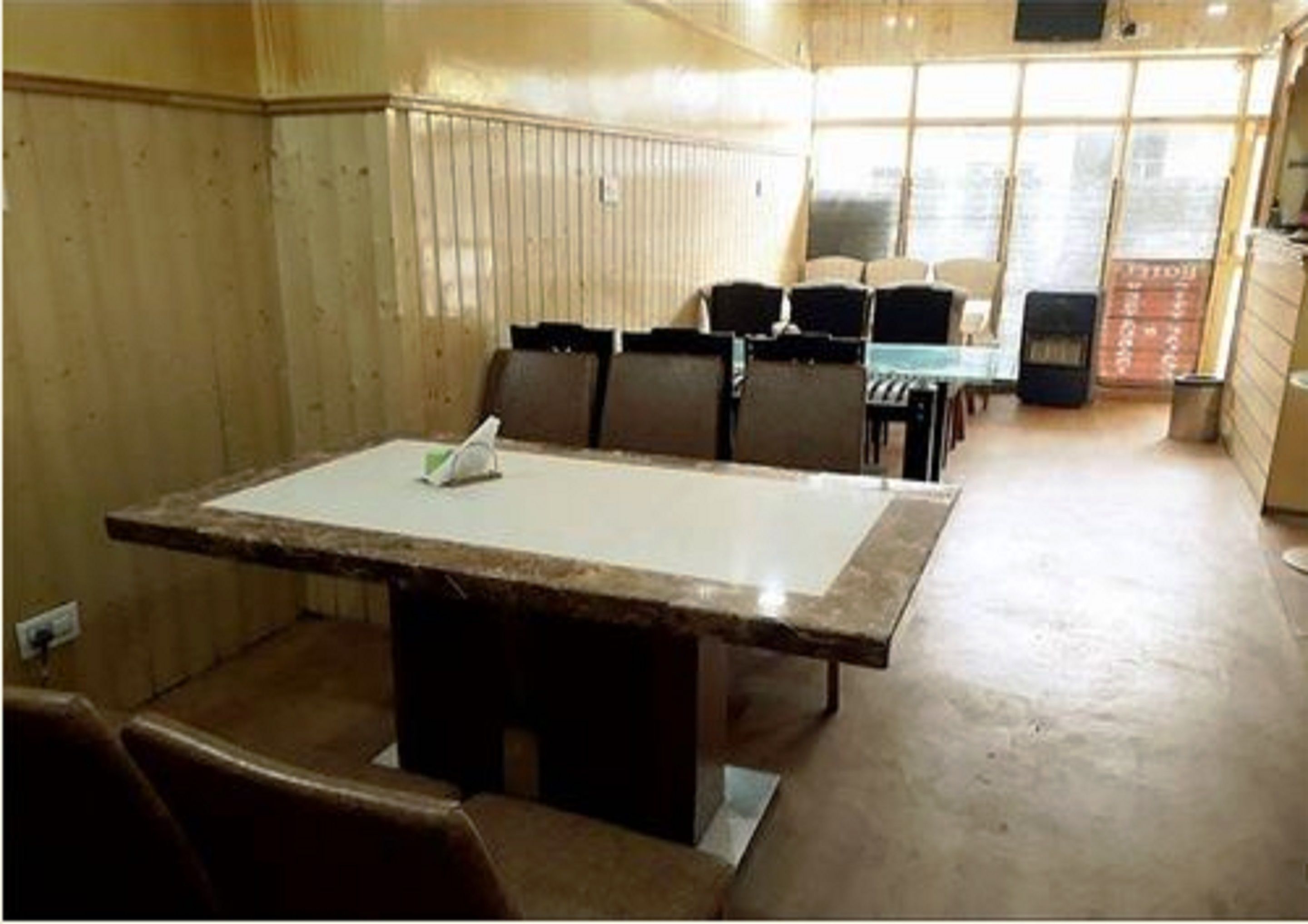 A conference room with a large table, chairs, and a window with blinds.
