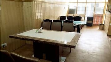 A conference room with a large table, chairs, and a window with blinds.