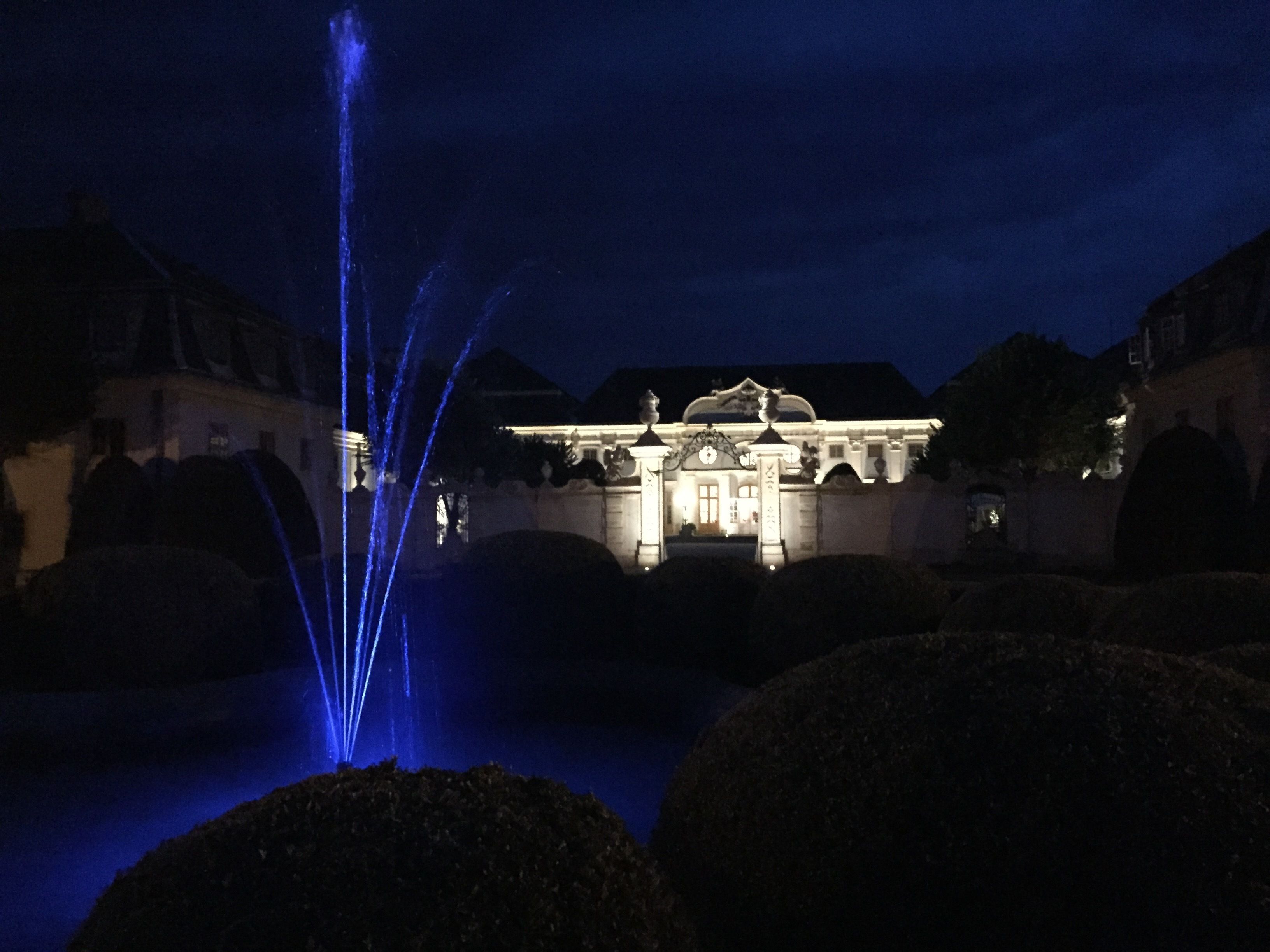A grand building with a fountain in the foreground.