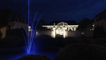 A grand building with a fountain in the foreground.