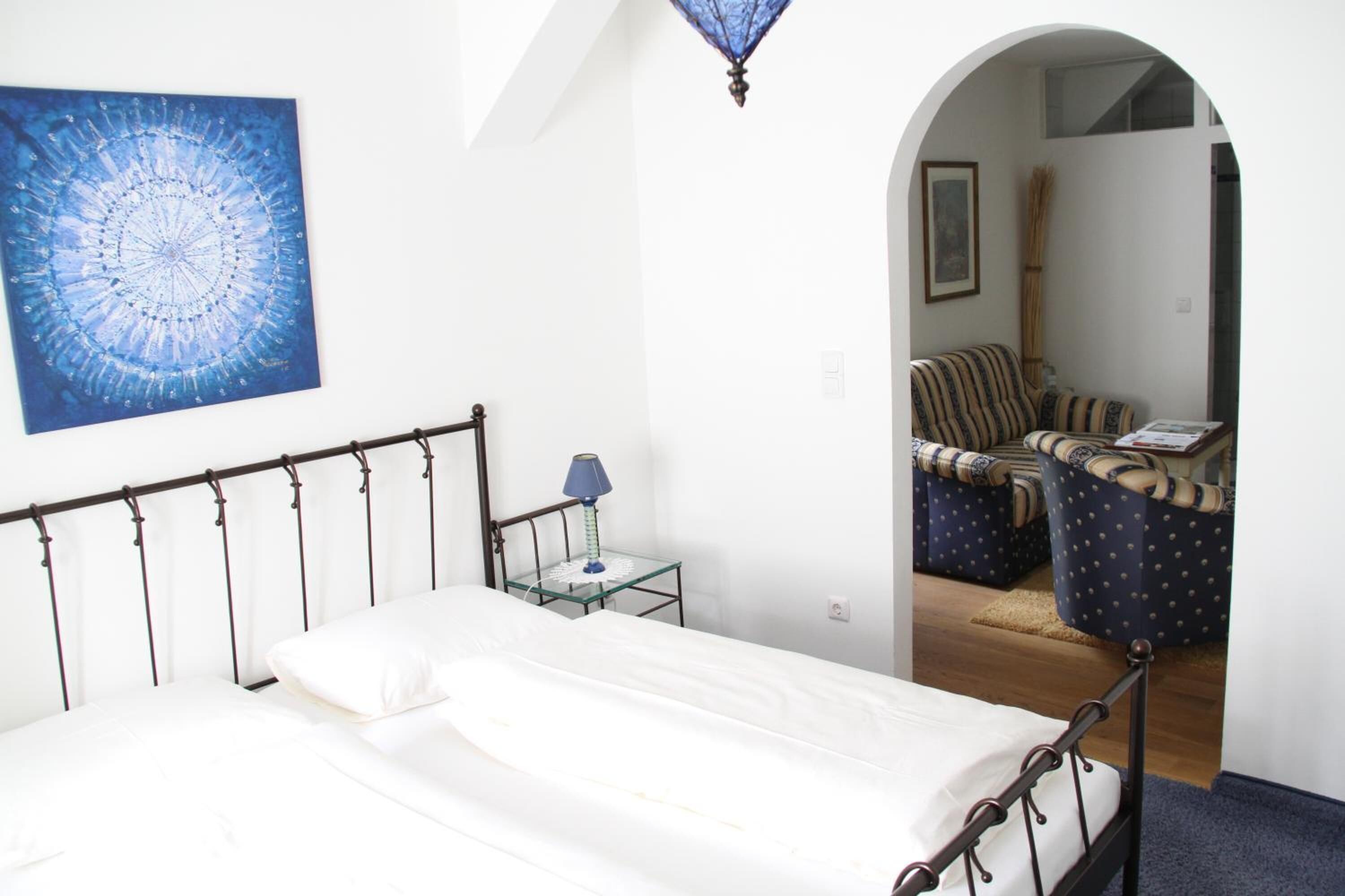 Une chambre à coucher avec un lit, une table de chevet, une lampe et un tableau au mur.