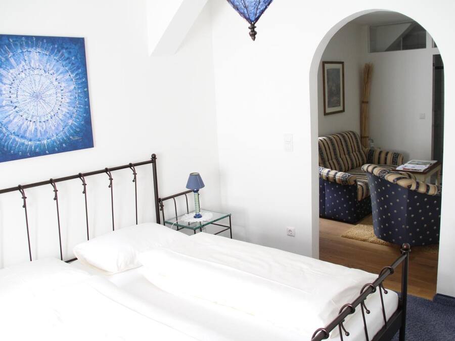 Une chambre à coucher avec un lit, une table de chevet, une lampe et un tableau au mur.